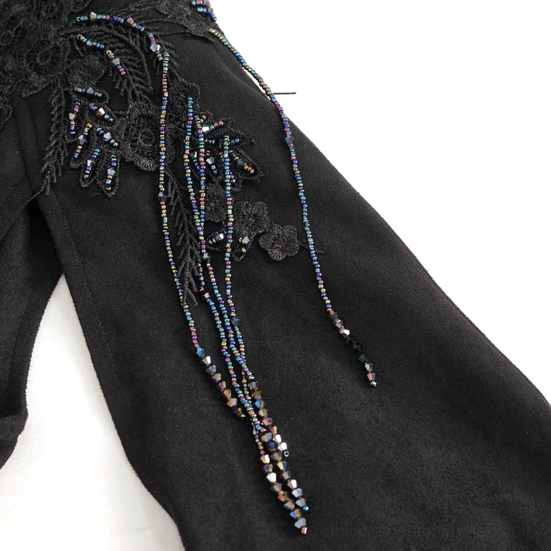 Detailed view of gothic crop top shoulder decoration with floral lace and beaded tassel trim