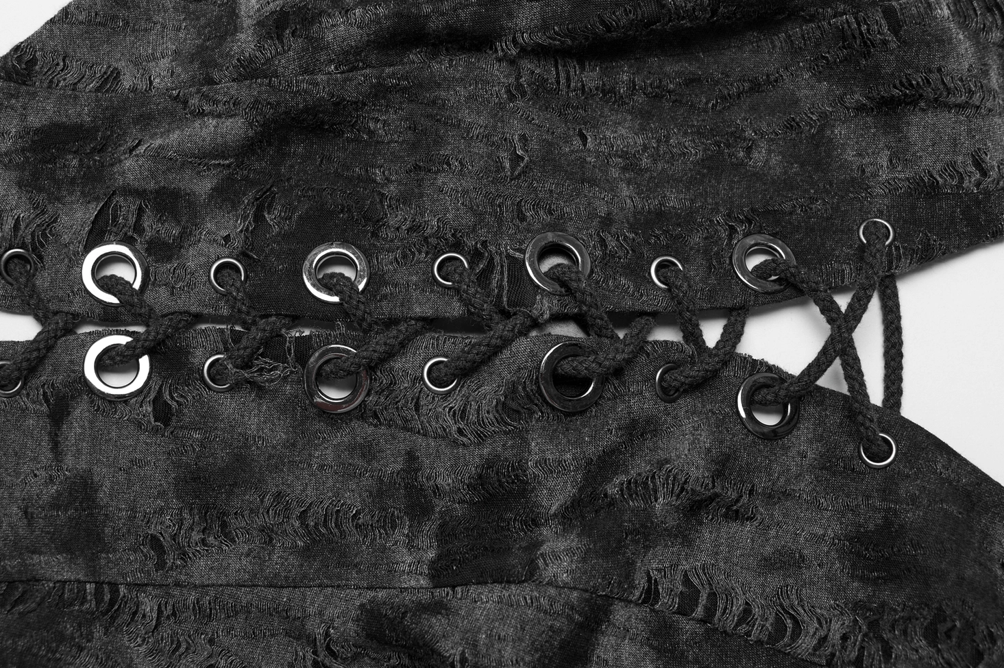 Fabric and hardware close-up of gothic lace-up crop top showing distressed black knit texture, metal eyelet grommets, and lace cord details