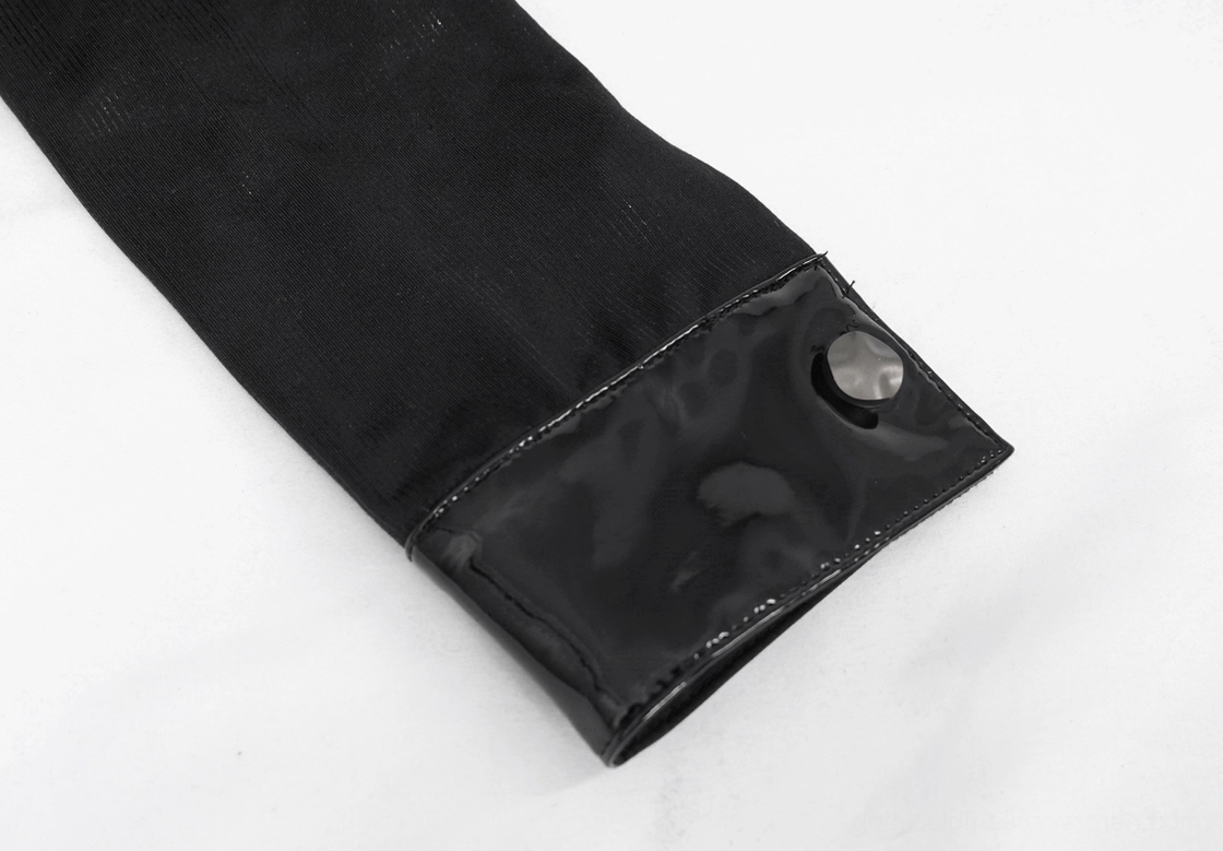 Macro close-up of gothic crop top sleeve cuff featuring patent leather accent with snap button closure