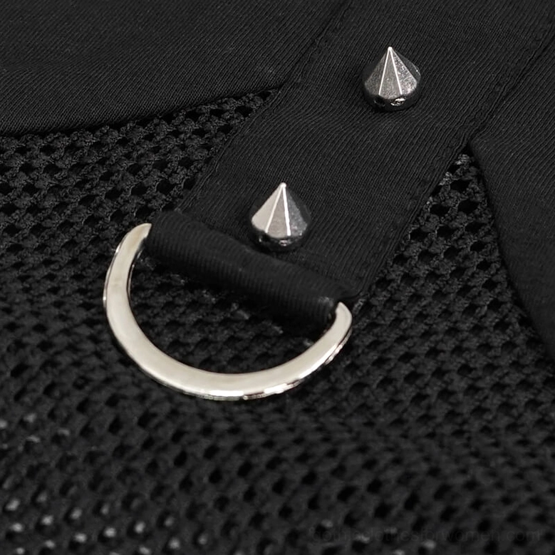 Close-up detail shot of cone spike studs and D-ring hardware on black fishnet mesh fabric