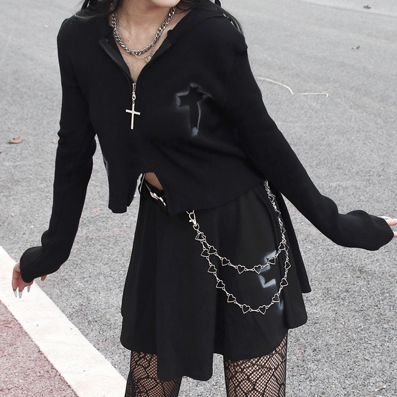 Gothic cropped zip sweater worn outdoors with pleated skirt and heart chain belt, side fashion shot