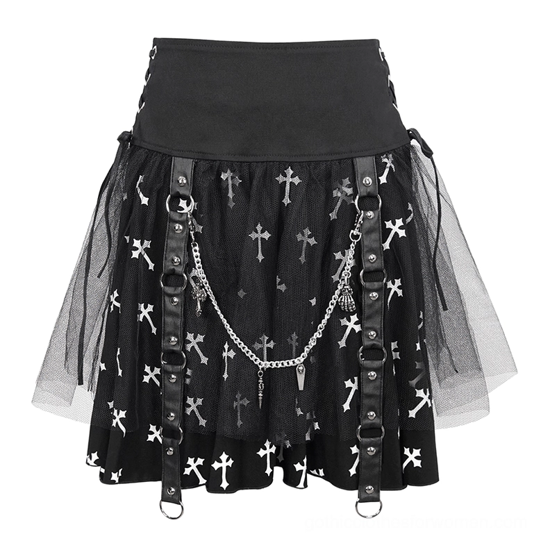 Close-up front detail of black gothic skirt showing leather side straps, metal chain decorations, tulle mesh layers, and white cross print pattern