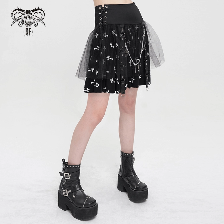 Model wearing black gothic cross print skirt styled with platform combat boots, showing side profile with chain and leather strap embellishments visible