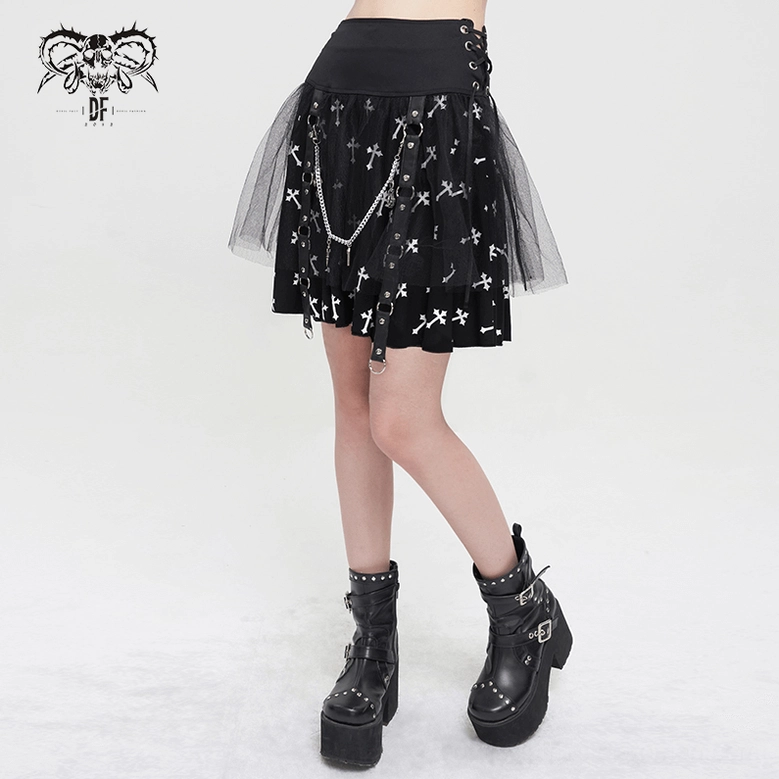 Three-quarter side view of black gothic cross print skirt on model with platform boots, showcasing cross print design, chain details, and mesh tulle layering