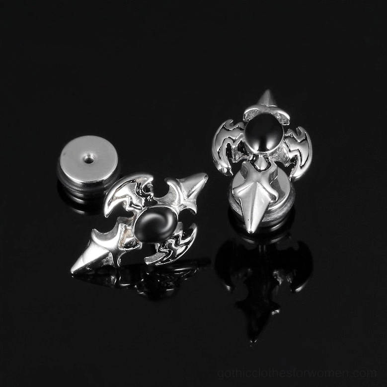 Paired silver gothic cross stud earrings with matching earring backs - flat view on reflective black background