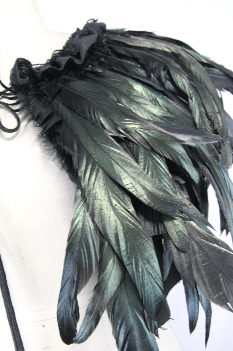 Single shoulder feather accessory on dress form showing black-green iridescent feathers and tie fixing