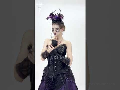 Female model wearing feathered gothic crown paired with matching purple goth dress, full front medium shot showing complete styled look