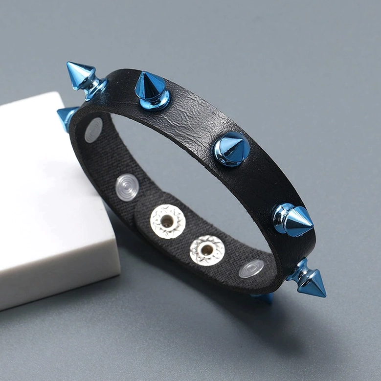 Dark gothic leather bracelet with blue metal studs angled flat lay detail photography