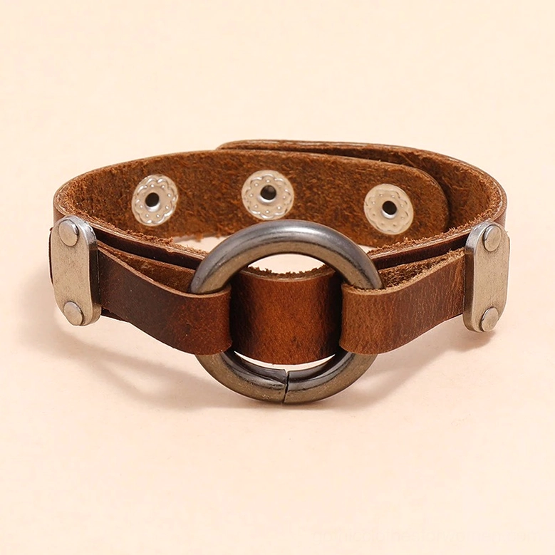 Aged brown PU leather gothic bracelet laid flat on neutral background, showing antique silver hardware, central O-ring, and adjustable snap fasteners