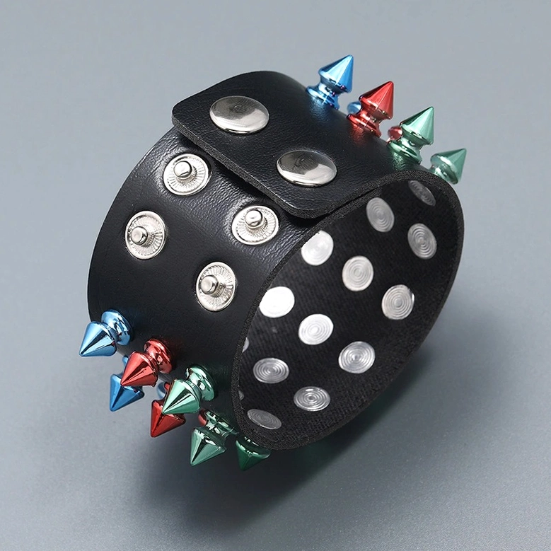 Partial view of gothic spike cuff displaying snap closure tabs and three-row metal spike arrangement