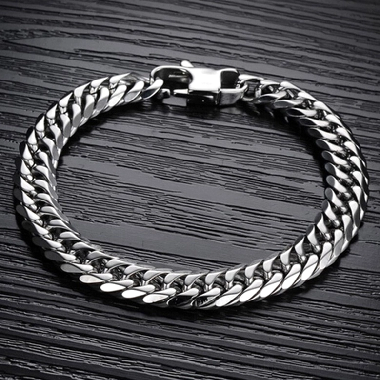 Stainless steel gothic bracelet flat overhead view on dark wood background showing complete closed chain design and lobster clasp