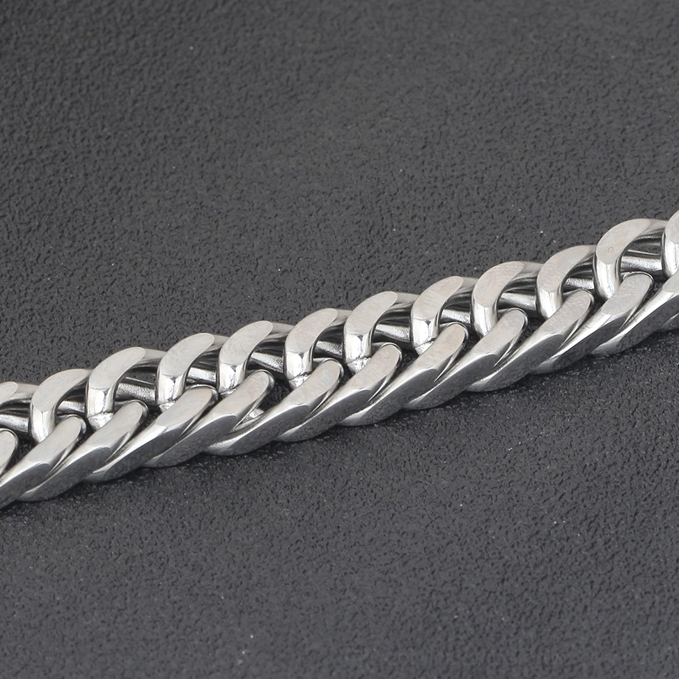 Close-up detail of interlocking stainless steel curb chain links showing precision engineering and polished silver finish