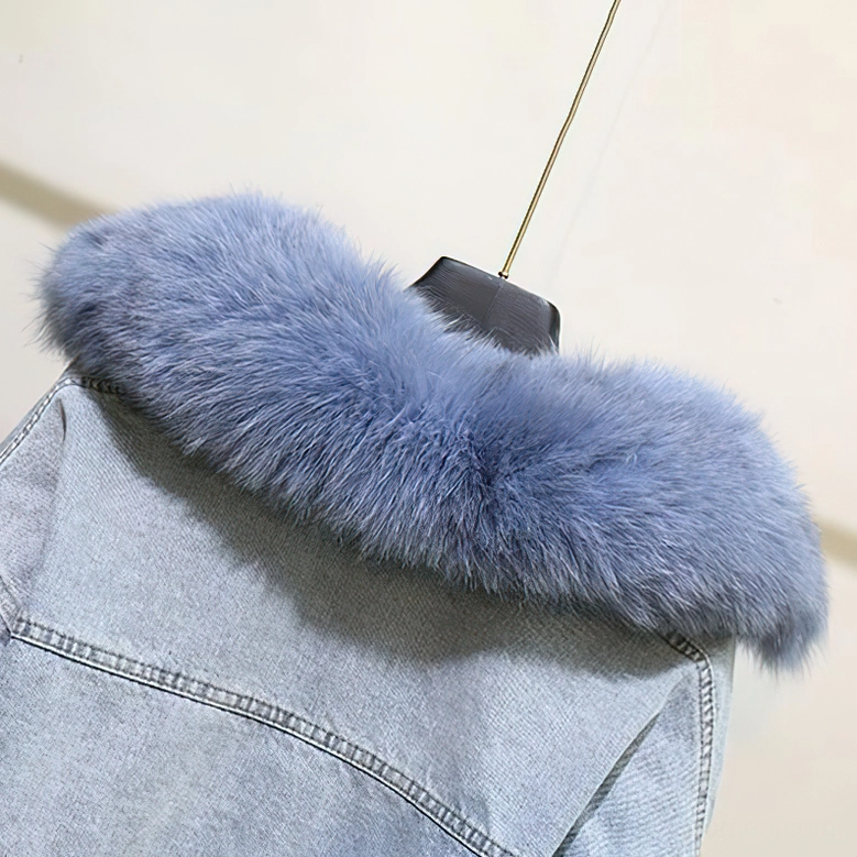 Close-up detail of light blue fox fur texture and washed denim fabric on gothic parka jacket