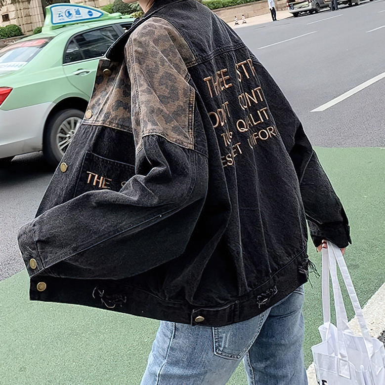 Alternative gothic denim jacket side back view, leopard print visible on shoulders and sleeves, outdoor setting