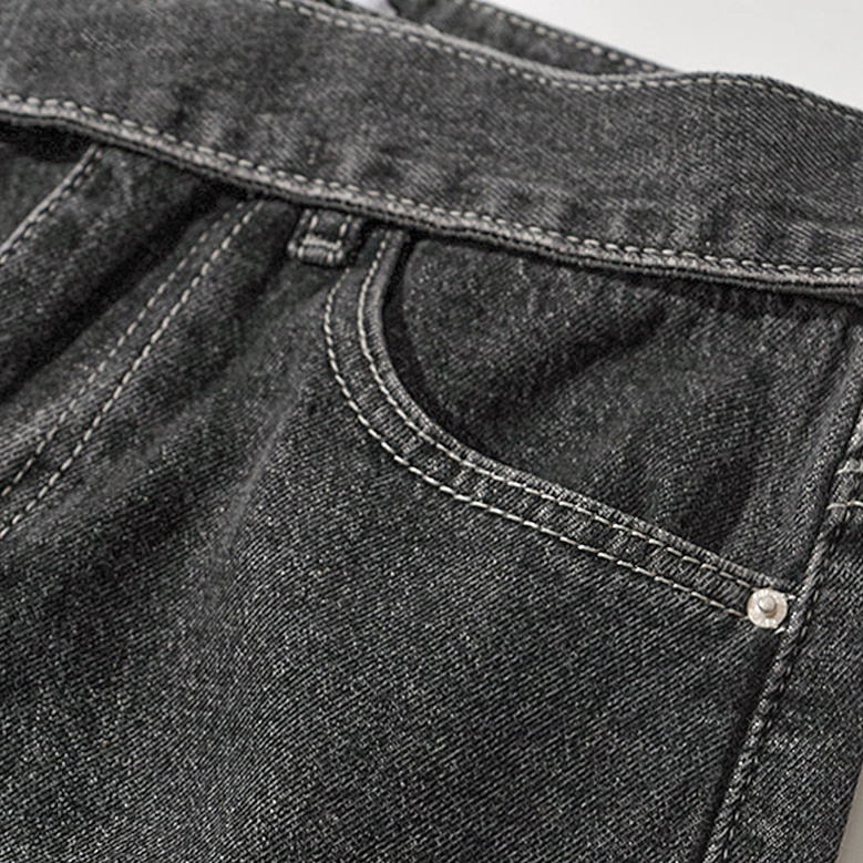 Gothic denim jeans front pocket detail showing metal rivet and professional stitching on dark fabric