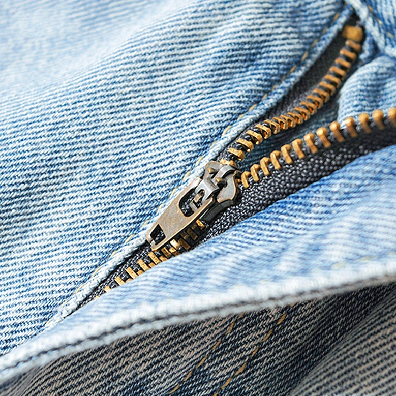 Gothic denim jeans light blue zipper fly close-up showing metal hardware and washed twill texture