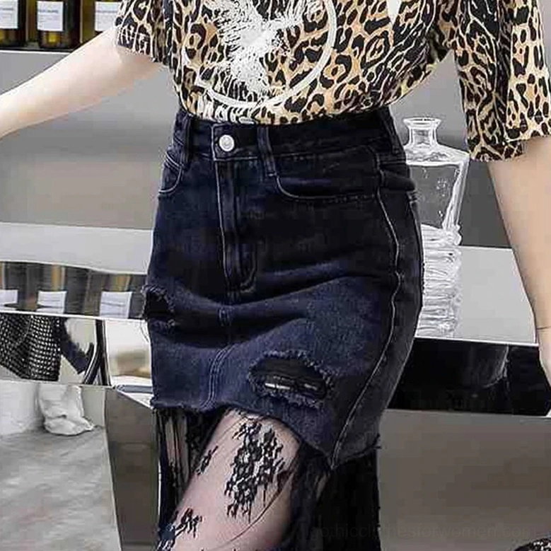 Black distressed denim gothic midi skirt lace detail - side close-up view showing split lace hem in modern indoor bar setting