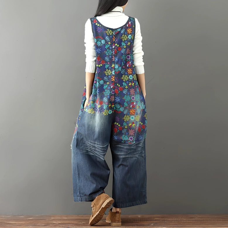Back view of distressed floral denim overalls featuring wide-leg cut and botanical print details on vintage-inspired garment