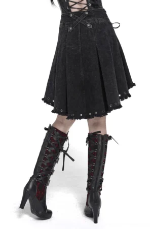 Gothic black denim skirt side profile view showing pleated silhouette, cross-back waist design and distressed hem