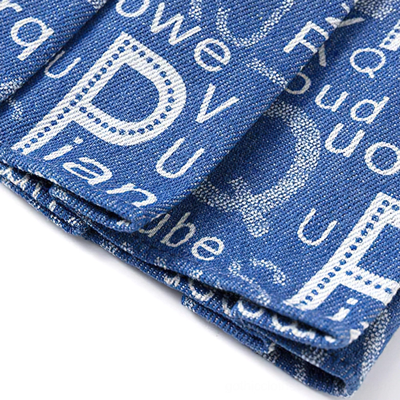 Typography denim pleated mini skirt worn side view on model, alternative fashion dark aesthetic styling