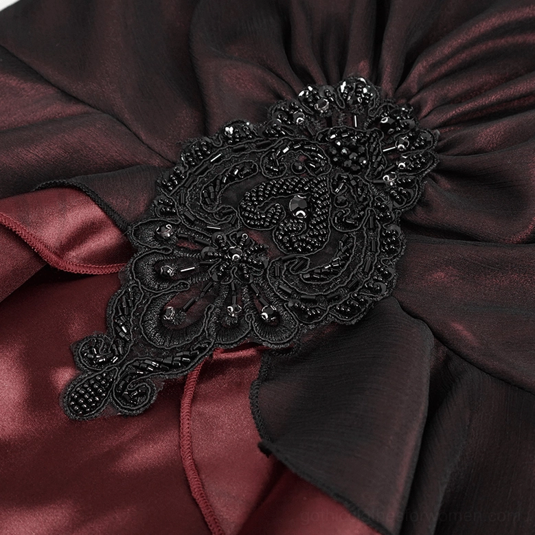 Macro shot of wine red gothic dress bust decorative appliqué with beaded lace ornament and ruched satin
