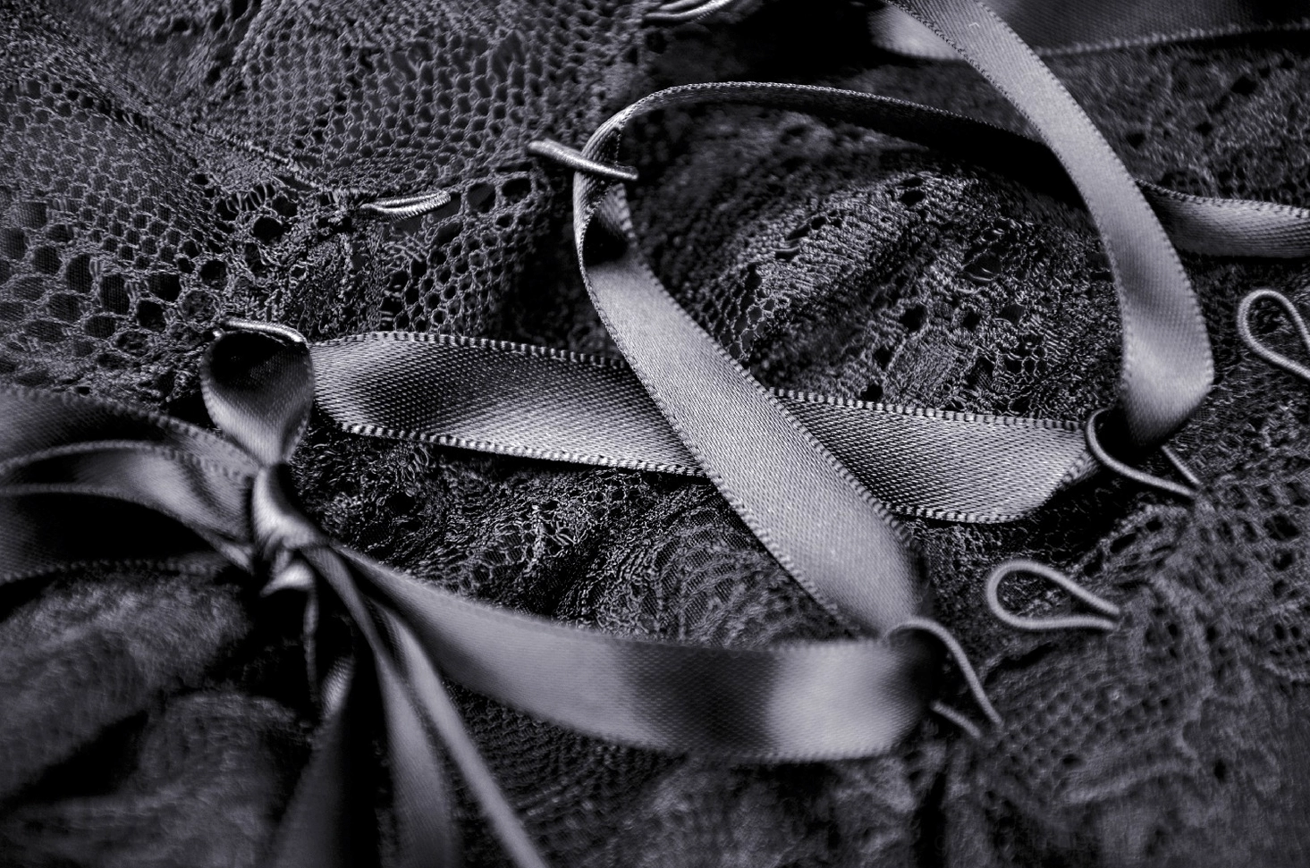 Top-down view of corset lace-up back with satin laces and metal hook fasteners detail
