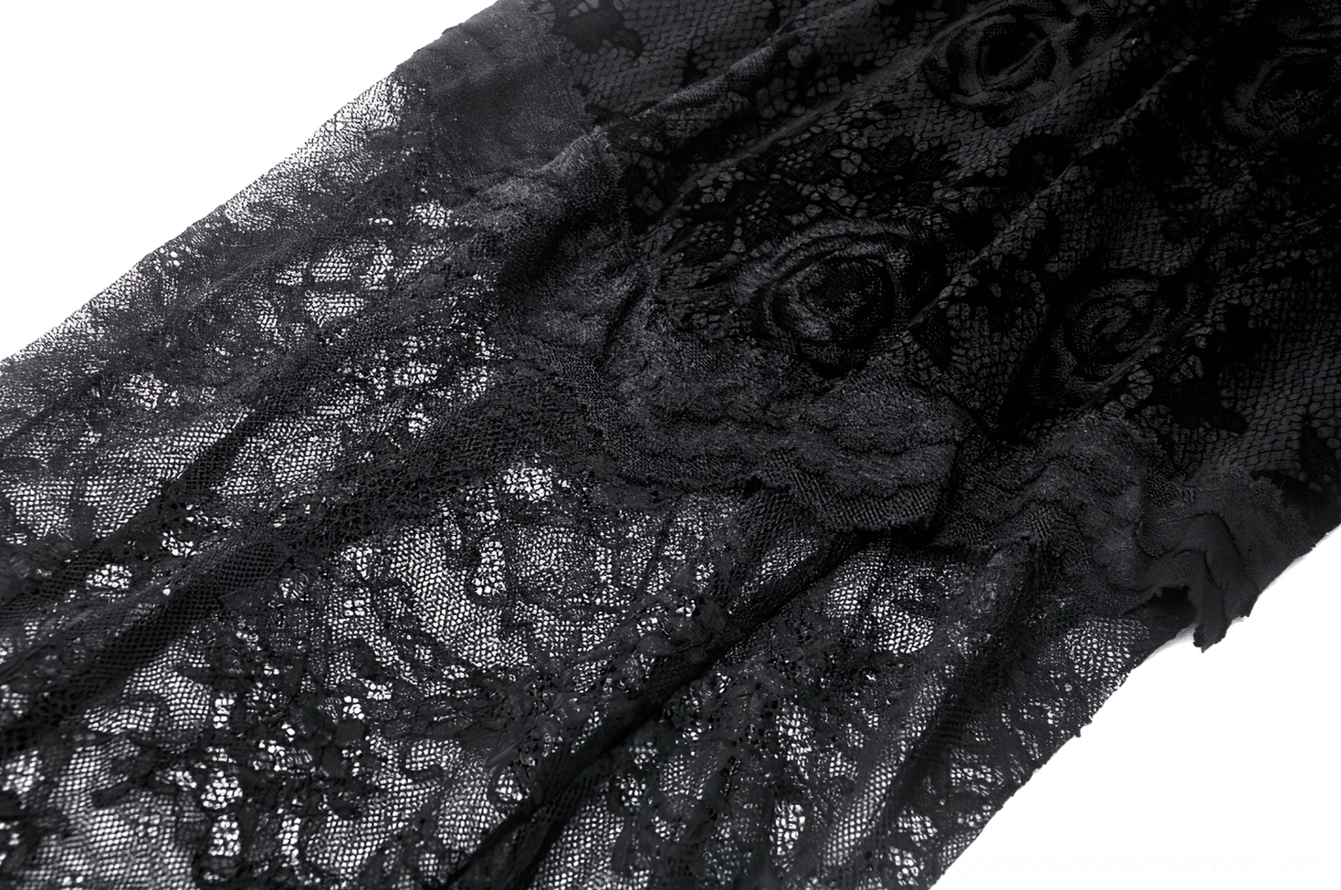 Fabric close-up of black gothic lace dress showing embossed rose floral texture, see-through lace weave, and soft ruffled edges