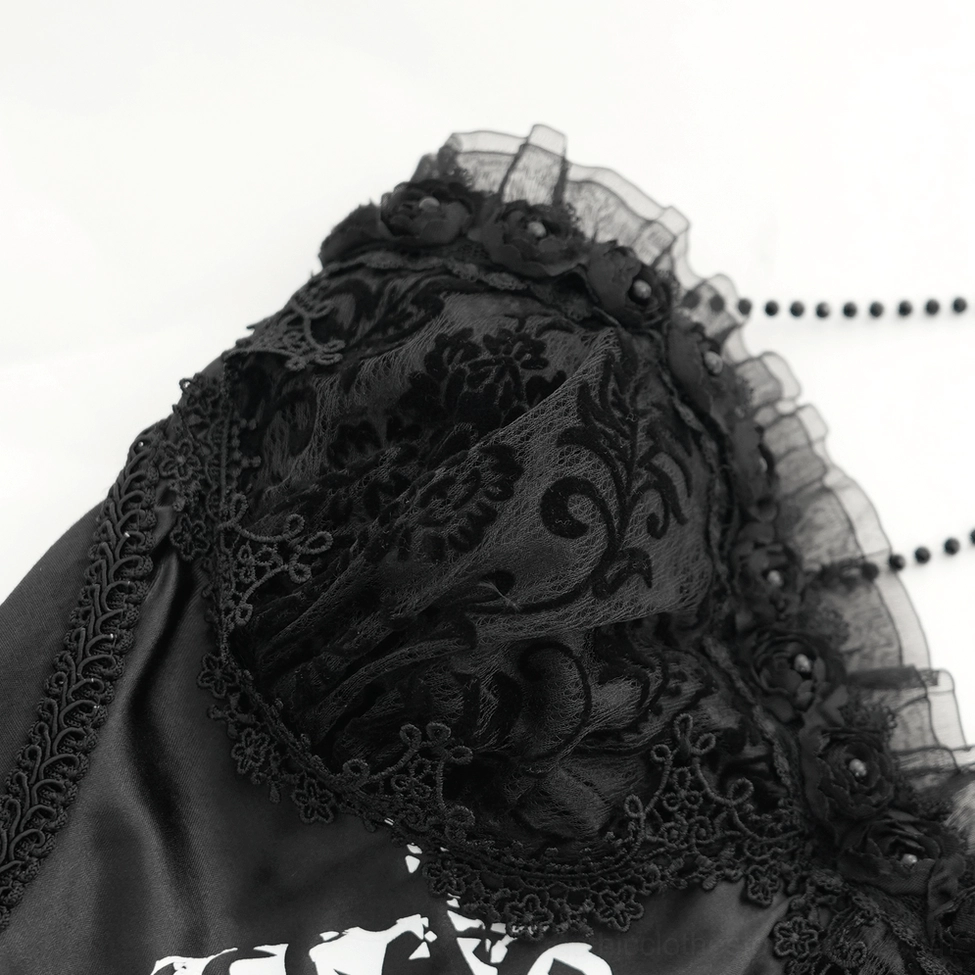 Close-up fabric detail of gothic dress showing velvet floral lace, ruffled trim, and ribcage print construction