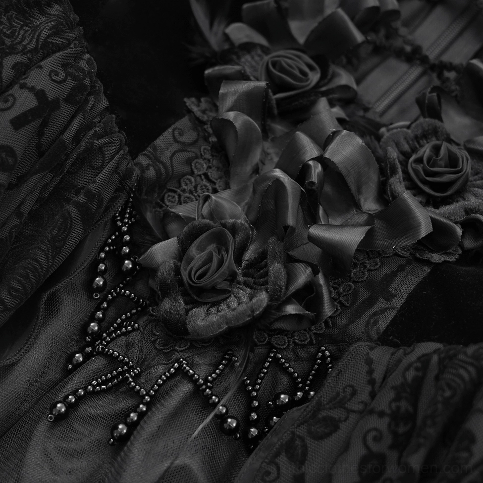 Close-up of black gothic dress embellishments showing satin rose ornaments and beaded web-like details on velvet-lace fabric