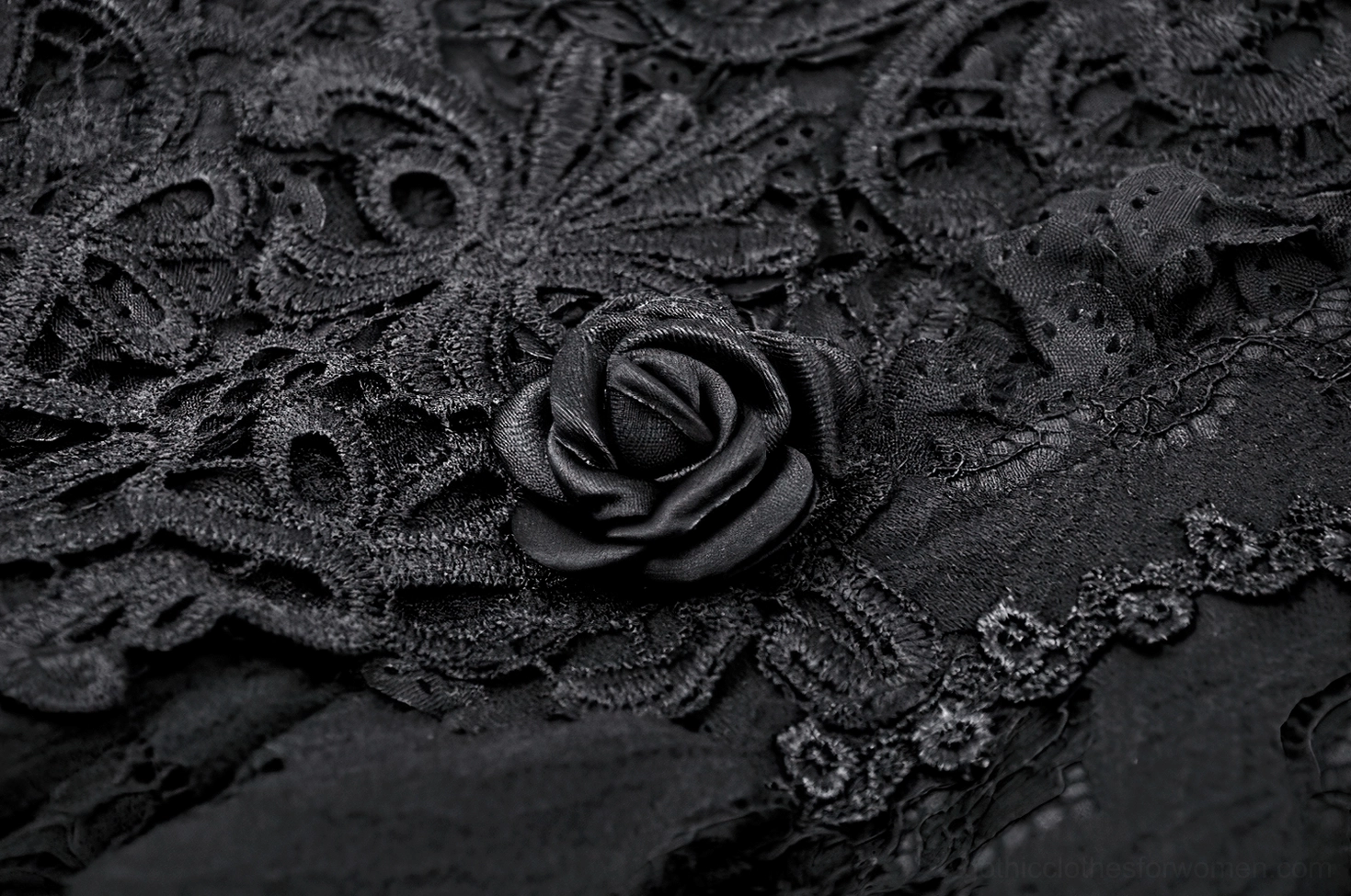Close-up of black gothic lace dress featuring intricate 3D fabric rose accent embroidery