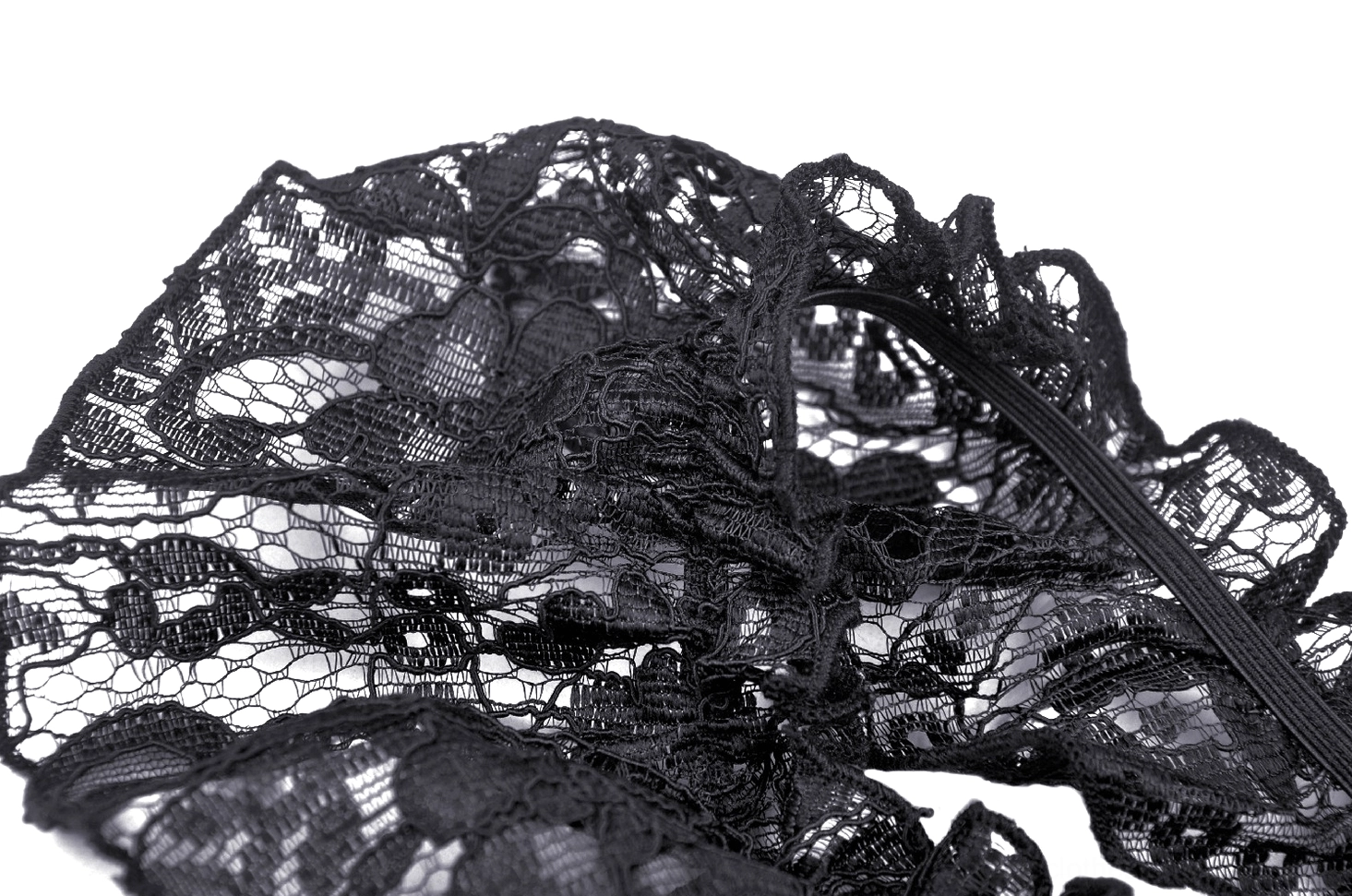 Close-up of intricate black floral lace pattern with ruffled edge on gothic dress overlay