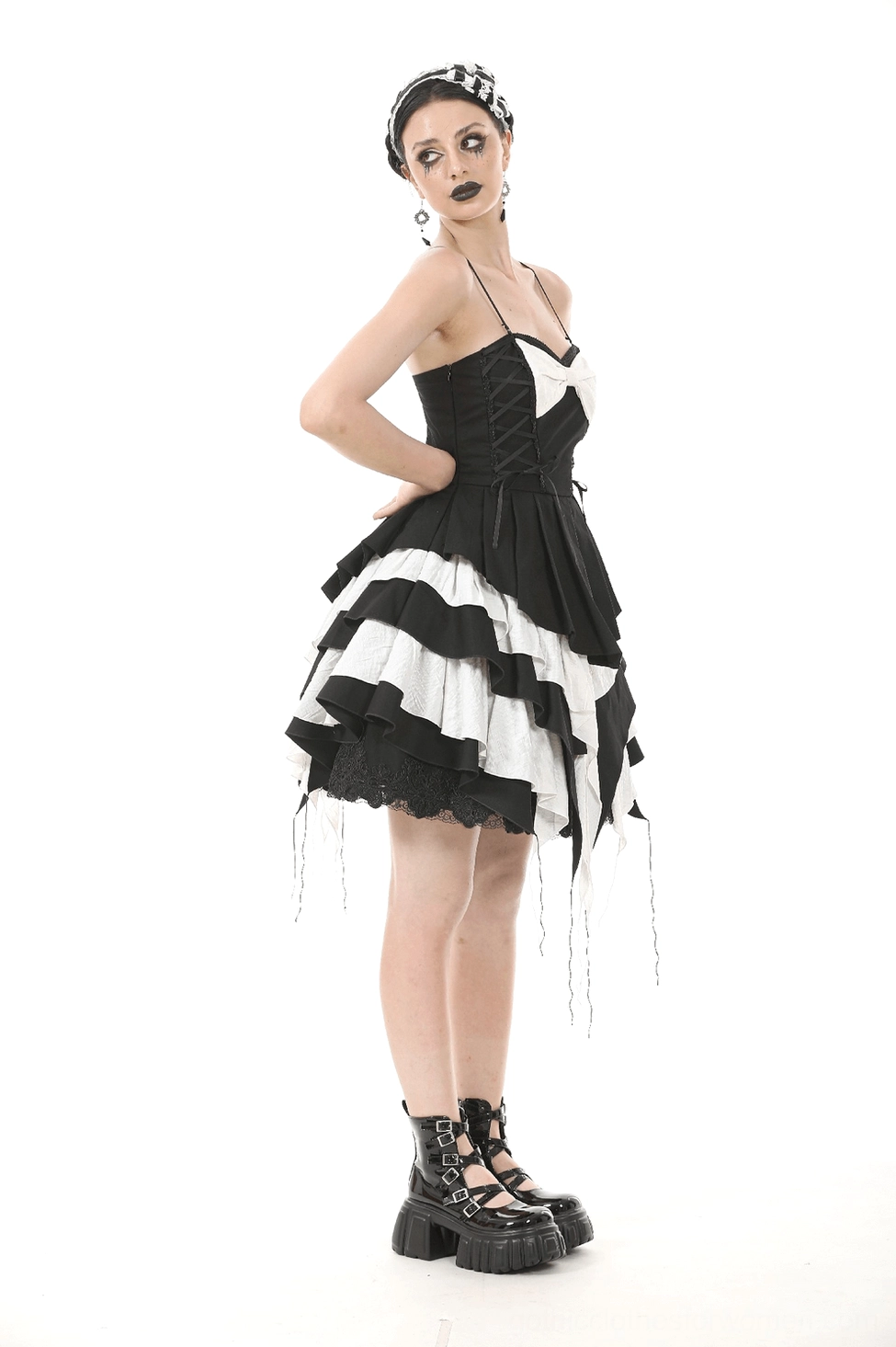 Black and white gothic dress detail shot showing hem tassels and ruffled layering on alternative fashion piece