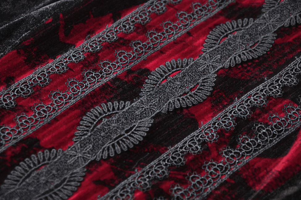 Black lace pattern detail on gothic dress front showing red velvet underlay contrast