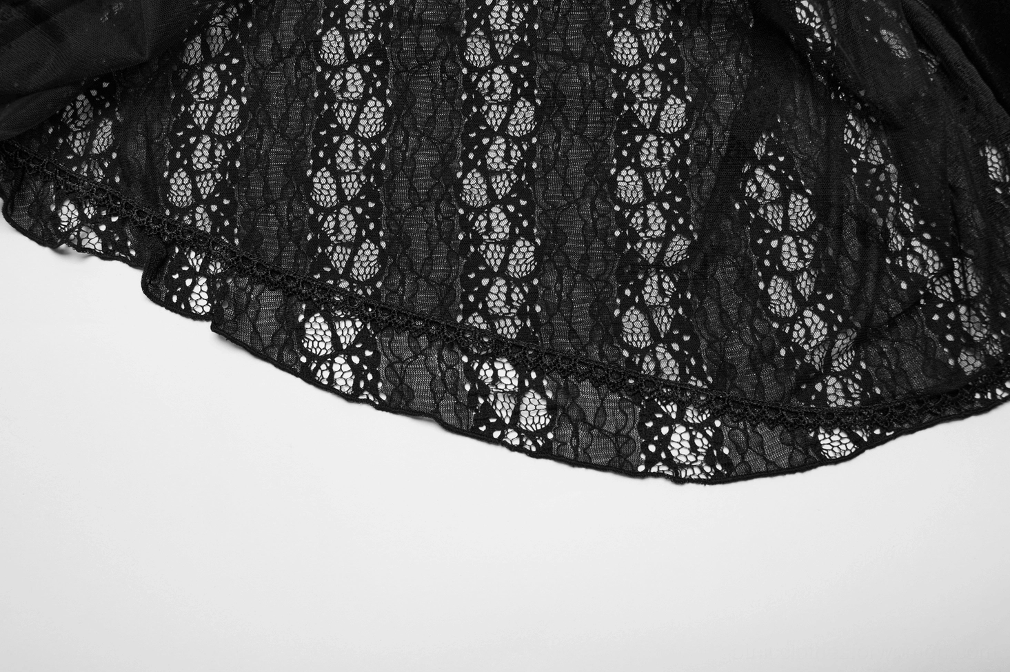 Close-up detail of ornamental floral lace trim and scalloped edge on black velvet mesh gothic dress hem