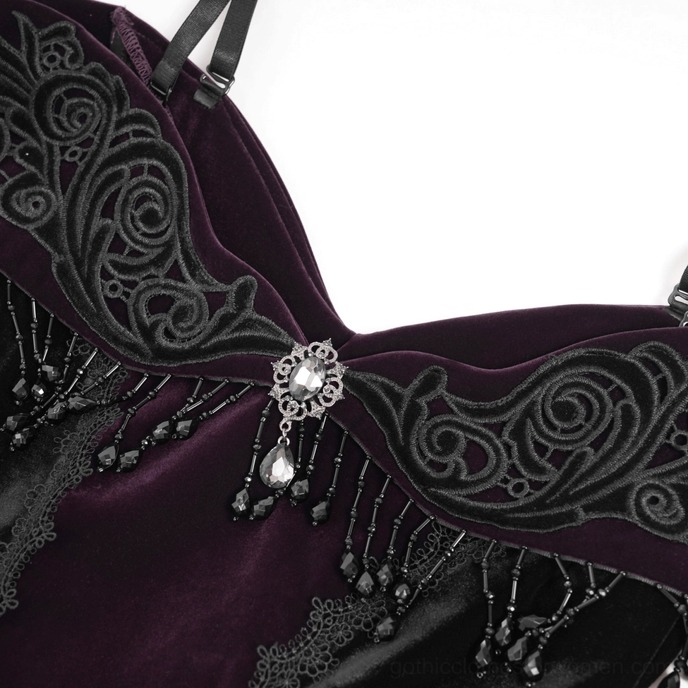 Close-up of gothic dress neckline embroidery and decorative hardware with jeweled brooch
