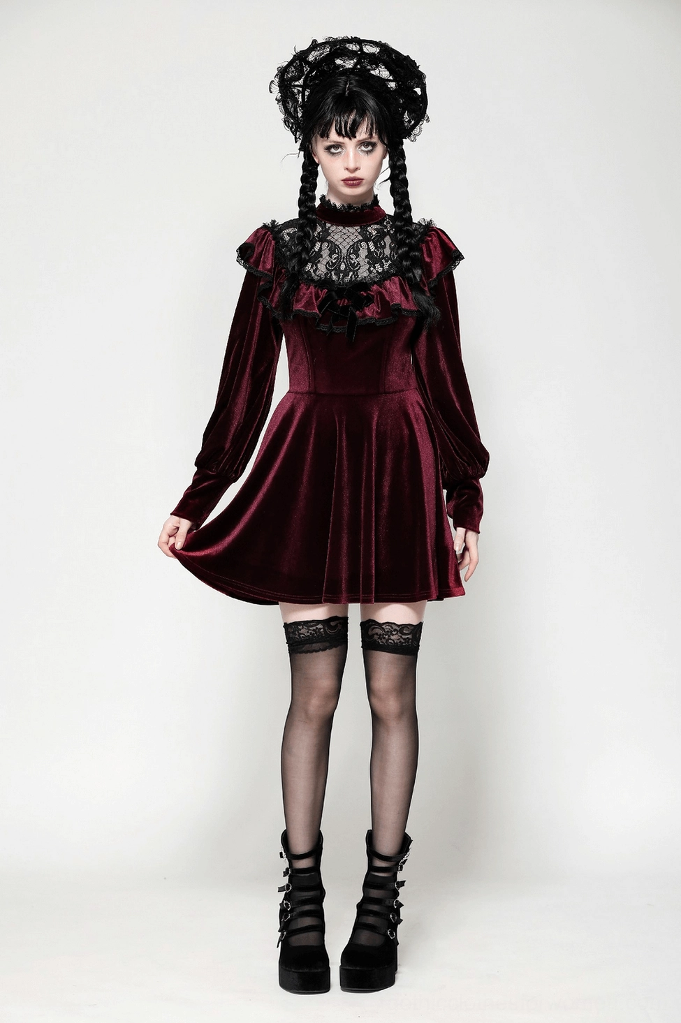 Gothic velvet mini dress puff sleeves and high neckline with bow detail on model