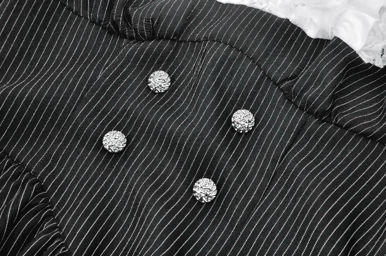 Macro close-up of gothic dress silver rhinestone round buttons and pinstripe weave fabric detail