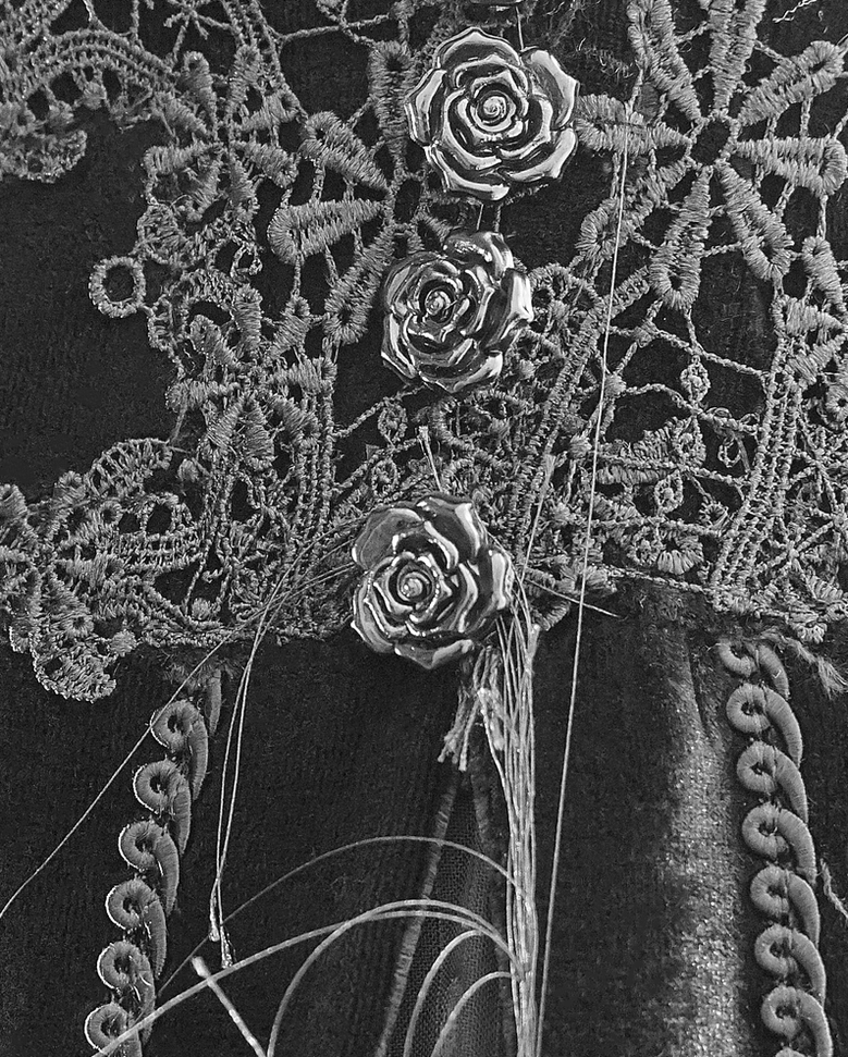 Detailed view of gothic velvet dress featuring rose floral lace decoration and chain trim embellishment on rich black velvet fabric
