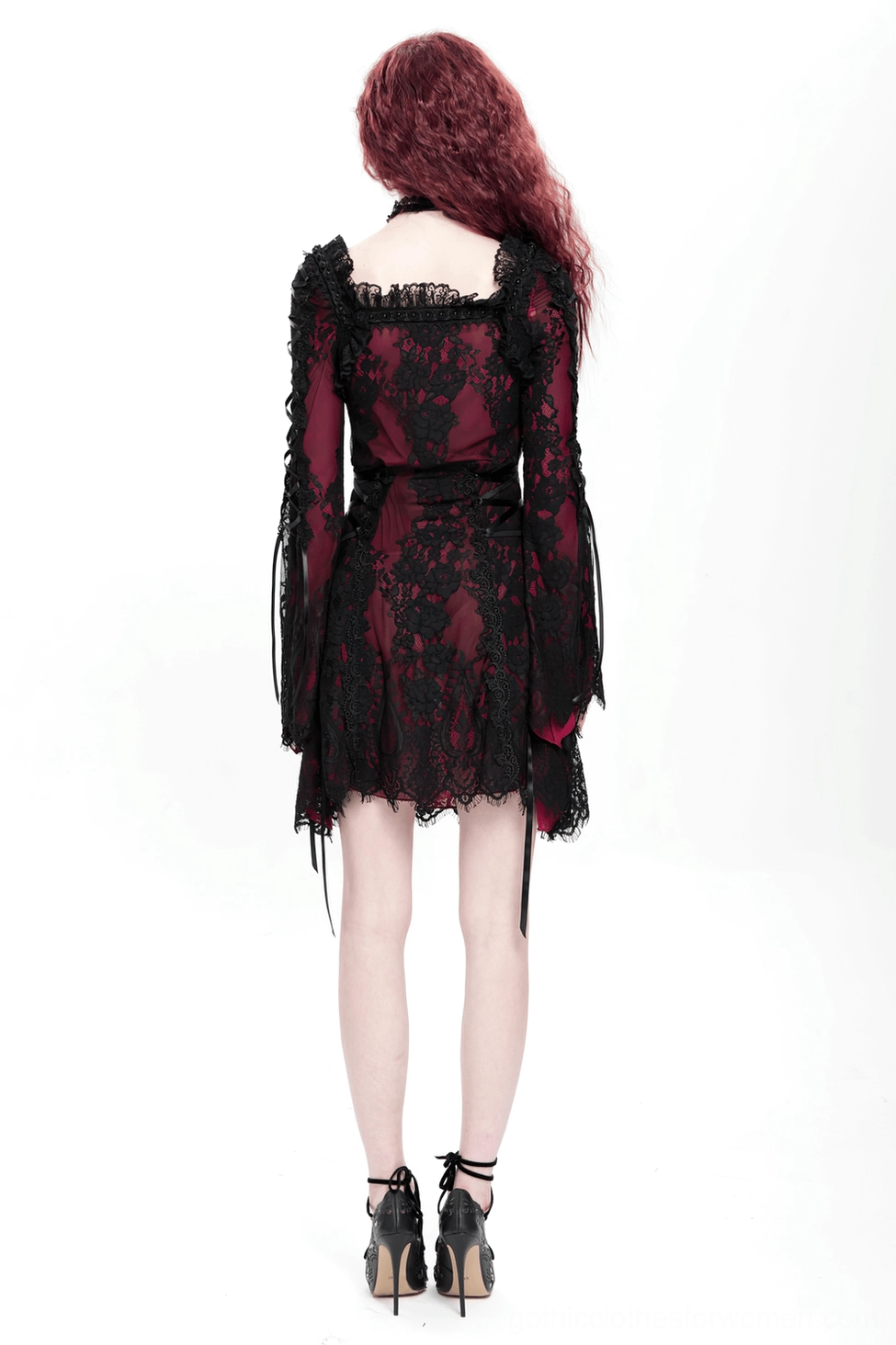 Close-up of gothic dress's lower hem section showing scalloped edge detail and black floral lace finish