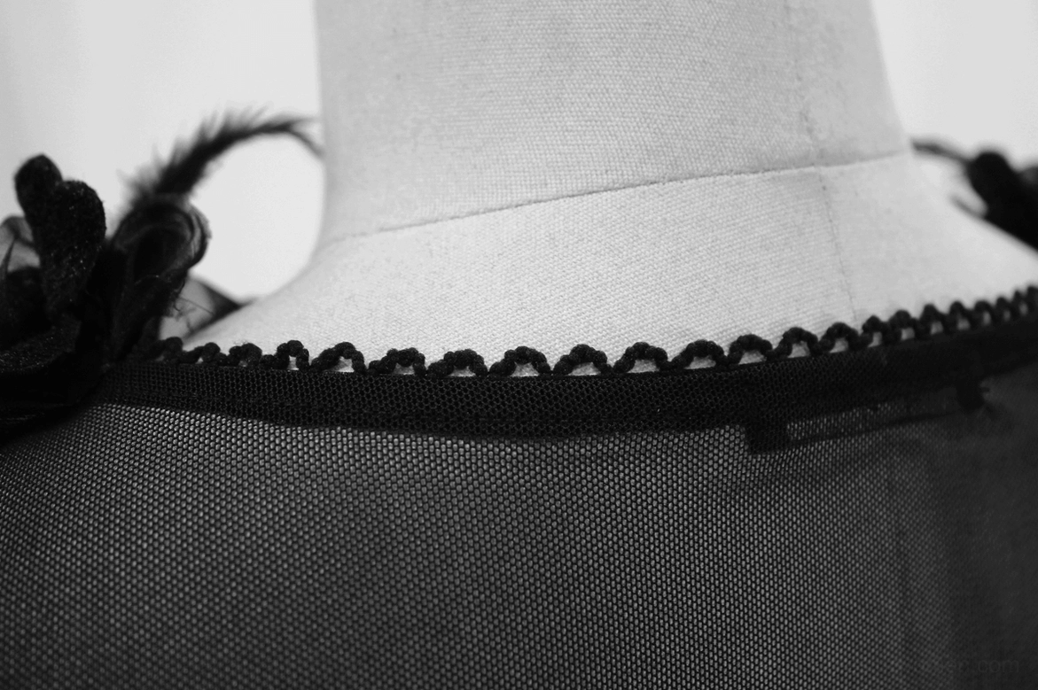 Close-up neck detail showing scalloped edge trim and sheer mesh fabric construction on gothic dress