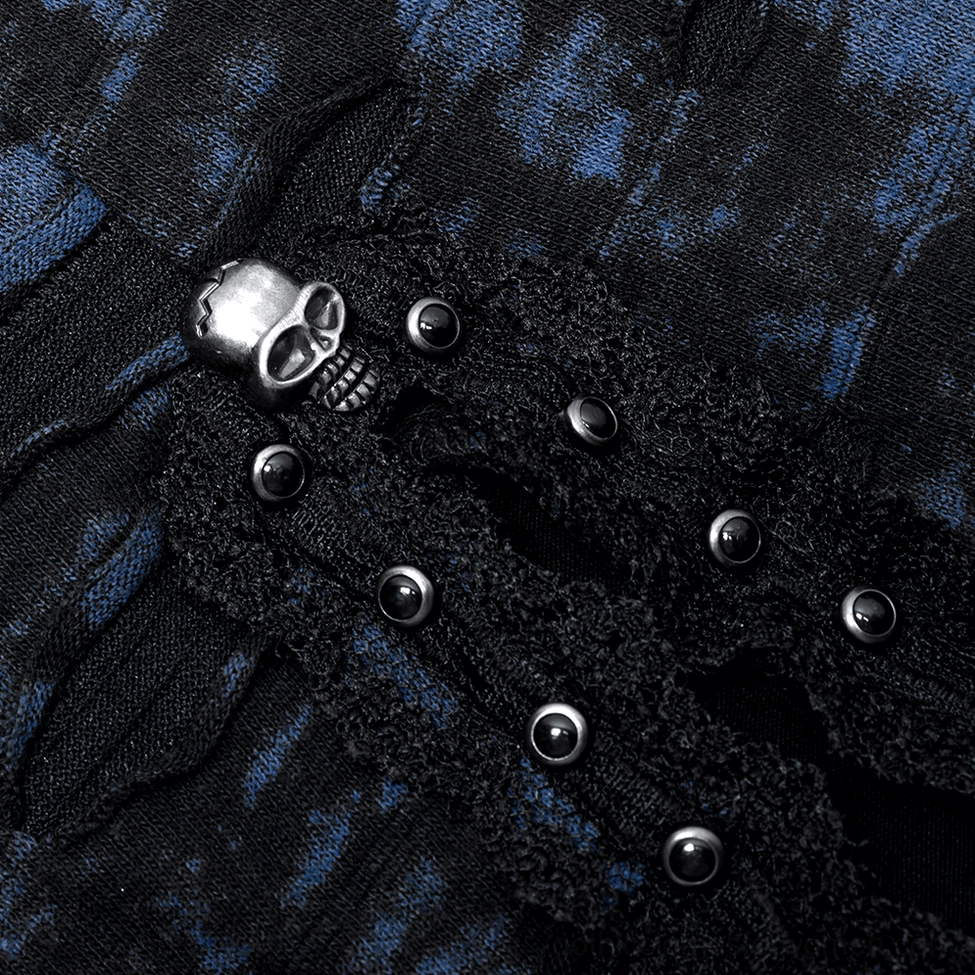 Skull-shaped metal buckle fastener and stud detail on gothic sequin dress trim and hardware close-up