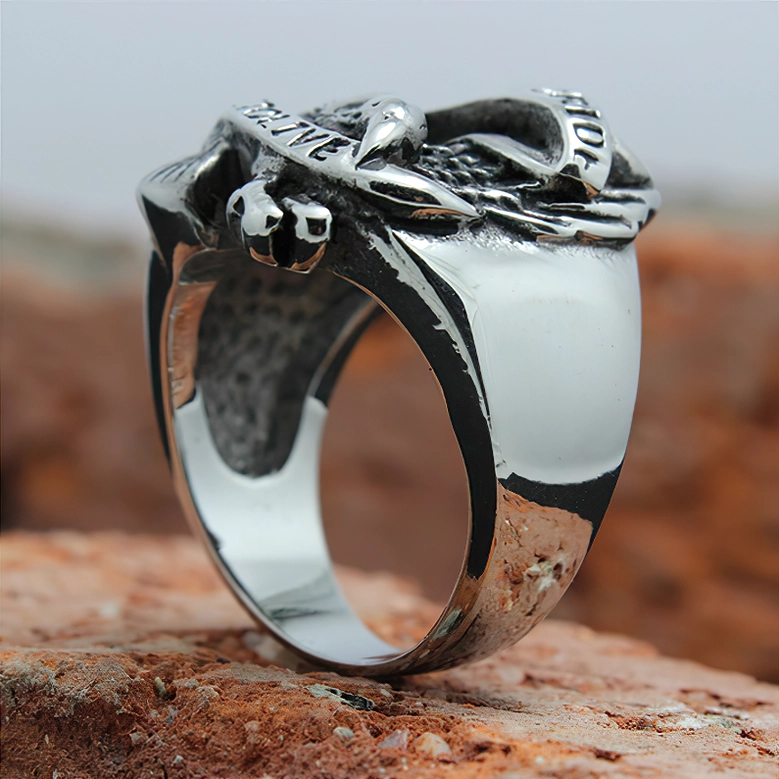 Biker eagle stainless steel ring interior smooth polished band, side view with outdoor rocky background