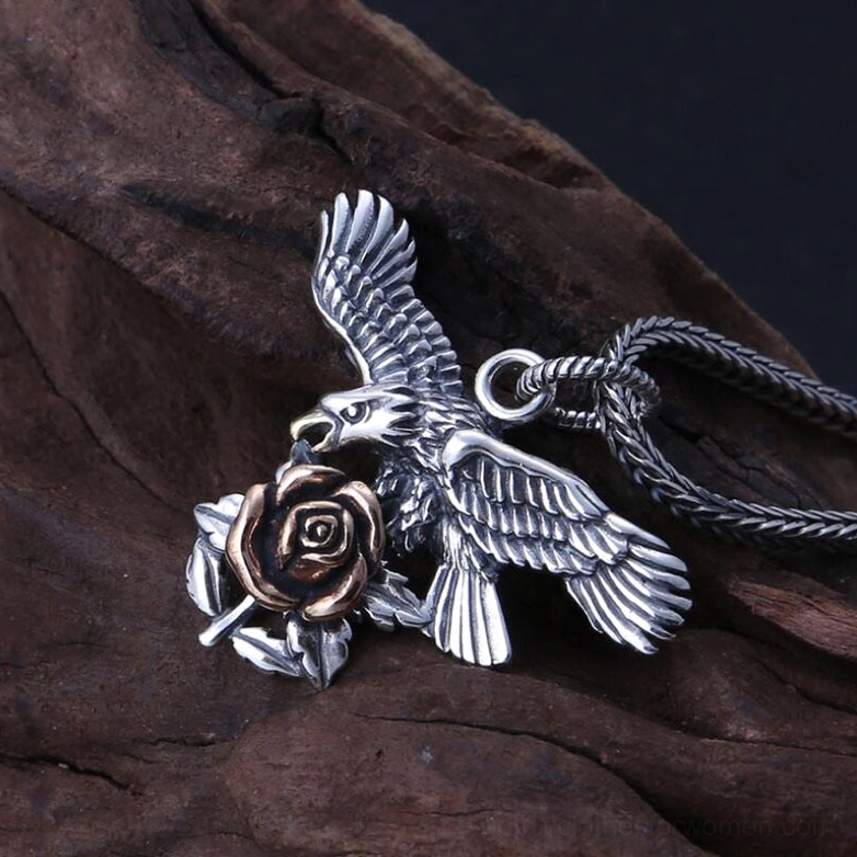 Side profile close-up of sterling silver gothic eagle pendant with bronze rose accent highlighting dimensional carving and craftsmanship