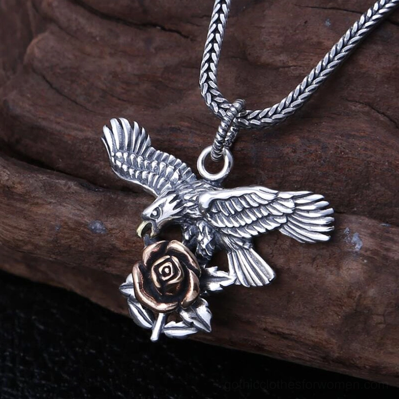 Three-quarter view of silver eagle and rose pendant necklace with twisted wheat chain showing elaborate wing and floral carvings