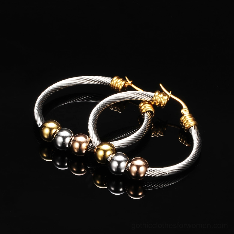 Polished metallic twisted gothic hoop earrings with tri-color beads on glossy black reflective studio background