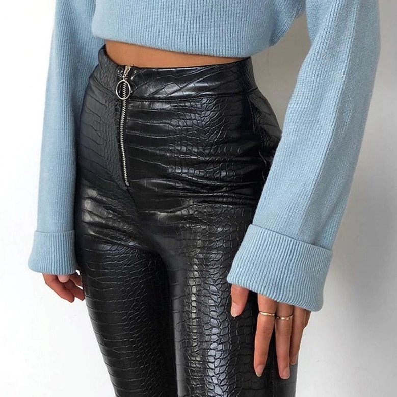 Oblique side angle of high-waist black gothic faux leather pencil pants on model, crocodile embossed texture, form-fitting leg design