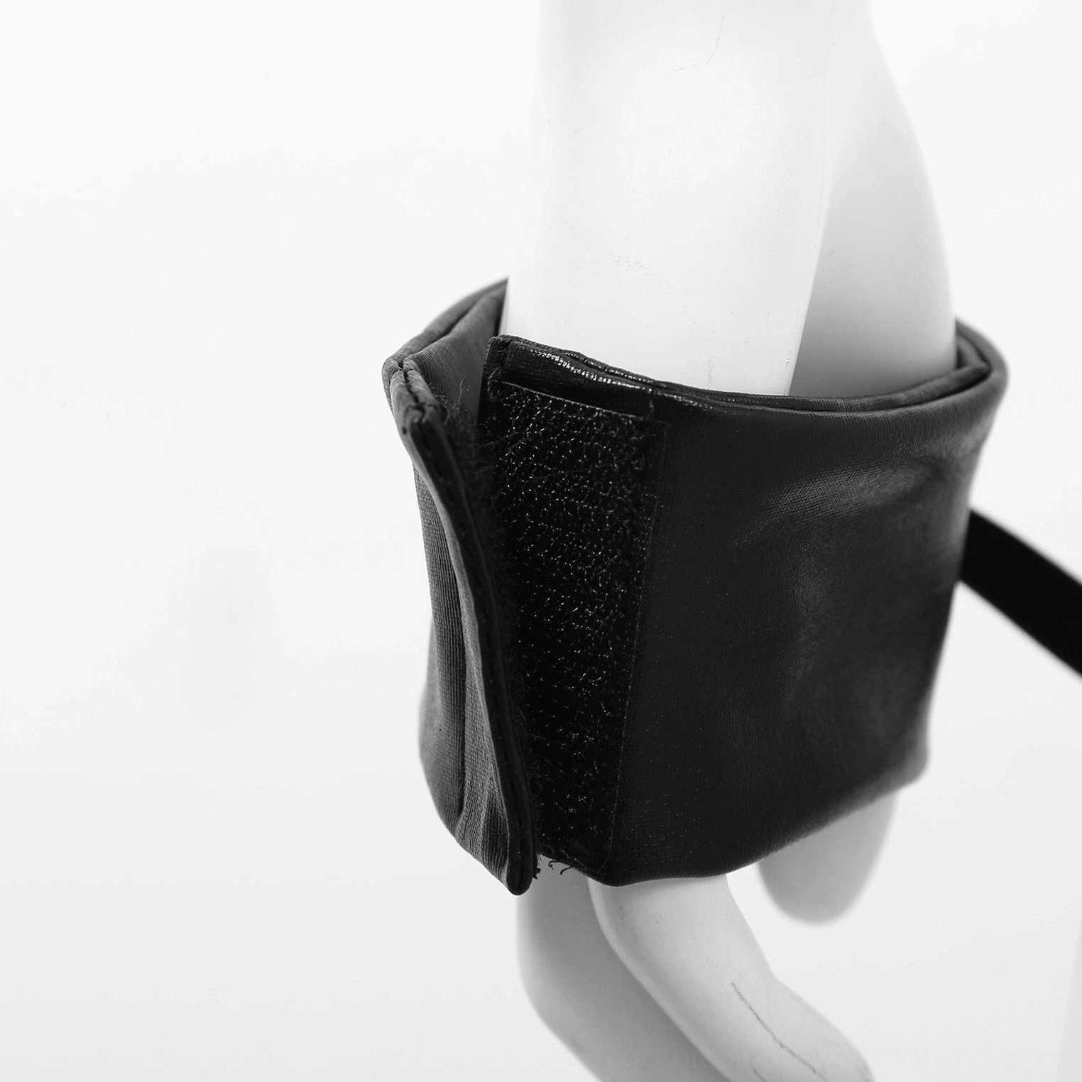 Faux leather wrist cuff accessory close-up, showing hook-and-loop fastener and smooth gothic leather texture