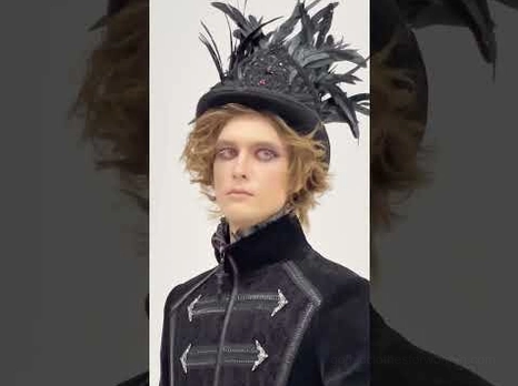 Black feathered top hat worn with gothic formal coat dark background aesthetic