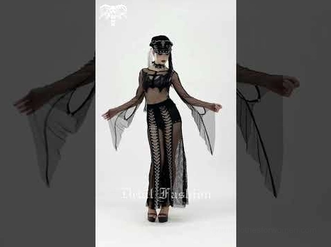 Female goth model wearing black fishnet chain pants with matching gothic accessories and dark studio lighting