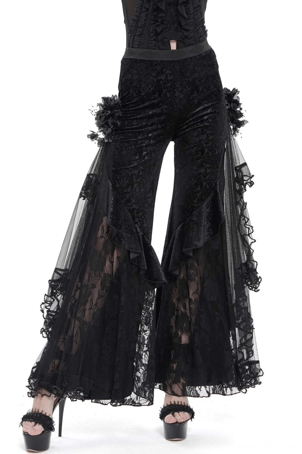 Black gothic flocked wide leg pants front view with lace ruffled sides and 3D floral flower decorations on female model
